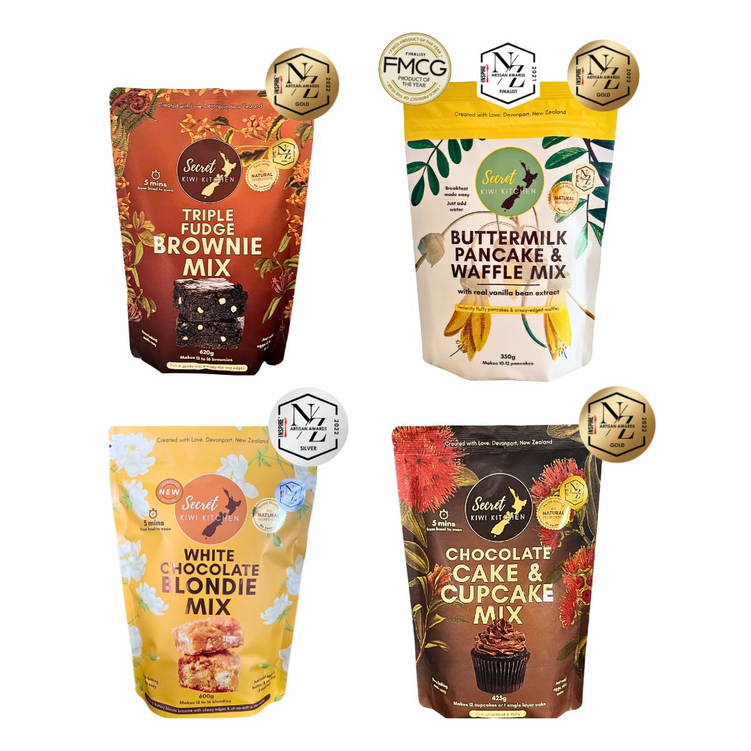 Four packages of Secret Kiwi Kitchen baking mixes on a white background